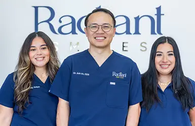 Smiling woman with dark hair sitting in the dental chair