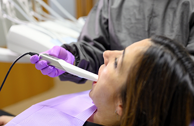 Dental patient having a dentist scan her teeth