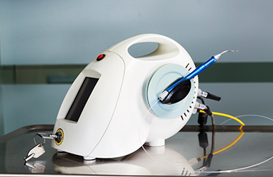 Pen like dental laser device attached via wires to a small device with a screen