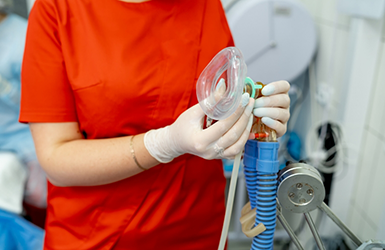 Dentist holding a nose mask for nitrous oxide