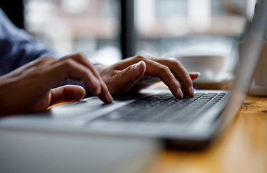 Person at a desk typing on a laptop