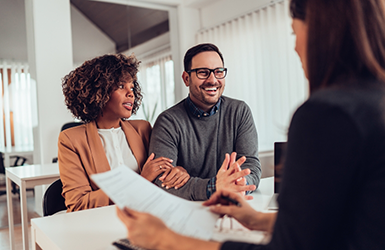 Man and woman sitting across a desk from a woman in a business suit