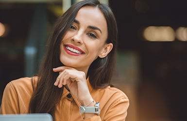 Brunette woman smiling in front of her laptop
