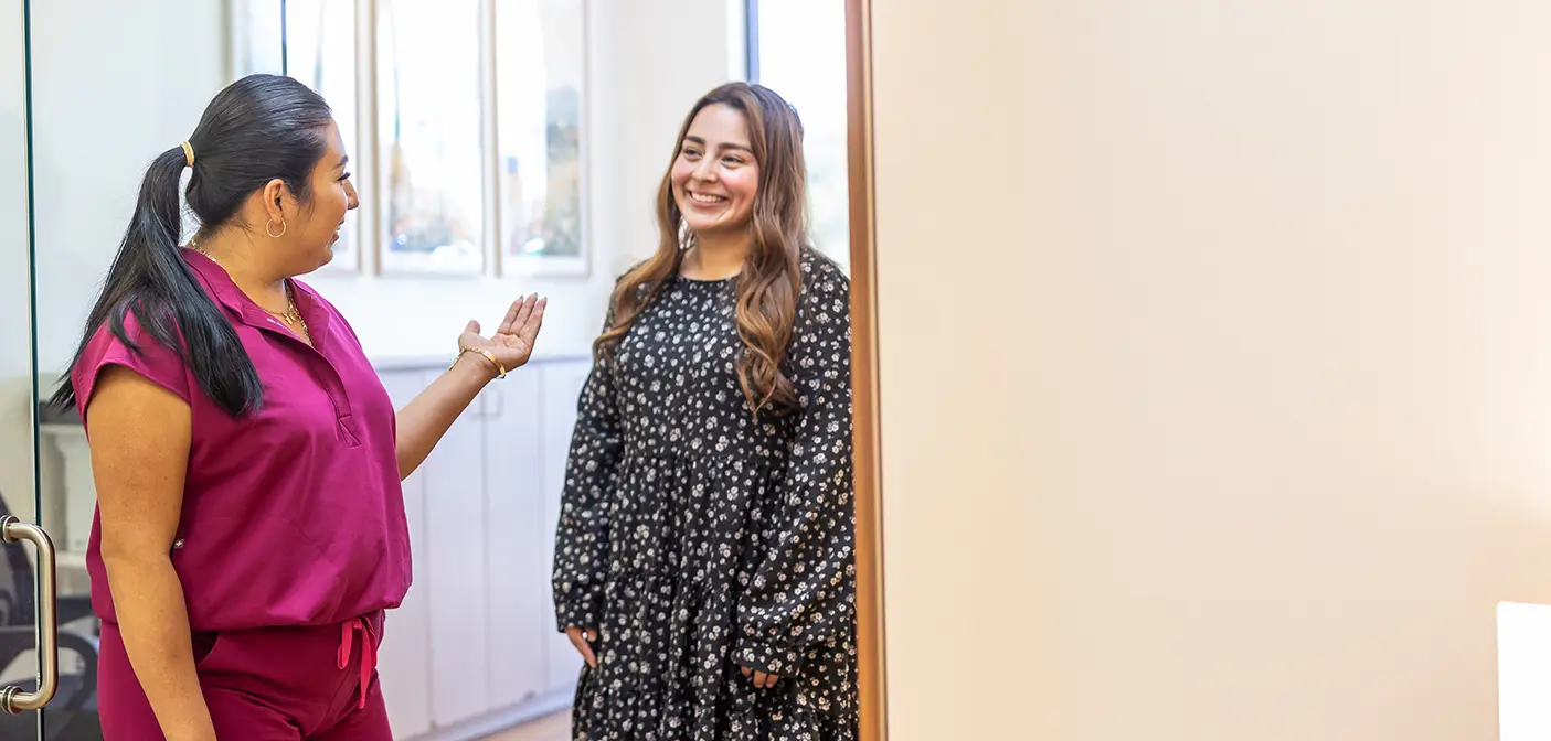 Man embracing woman from behind in a forest