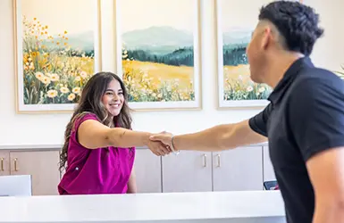 Person filling out dental insurance forms on a clipboard