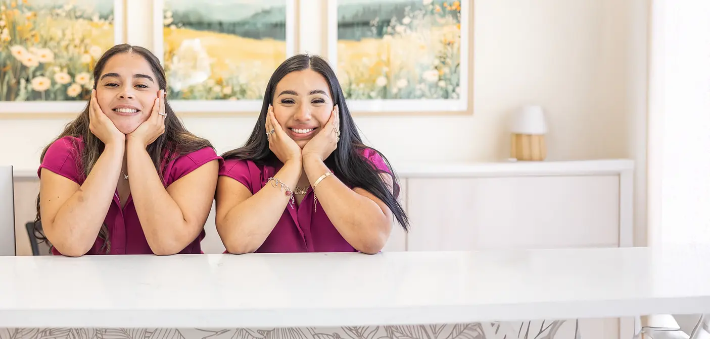 Doctor Vo smiling with the dental office in the background