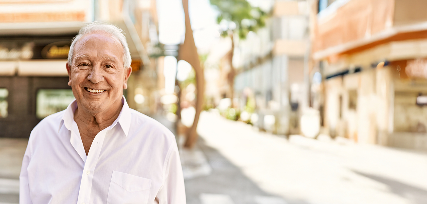 Senior man smiling outdoors after replacing missing teeth in Grand Prairie