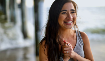 Woman with dark hair smiling outdoors