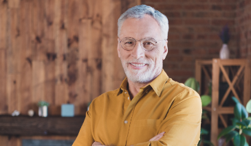 Smiling older man in a dark yellow button down shirt