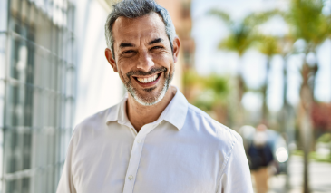 Man in a white dress shirt smiling in the sun