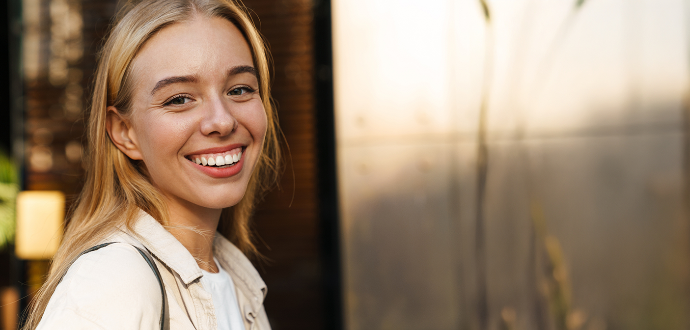 Smiling blonde woman in a white jacket