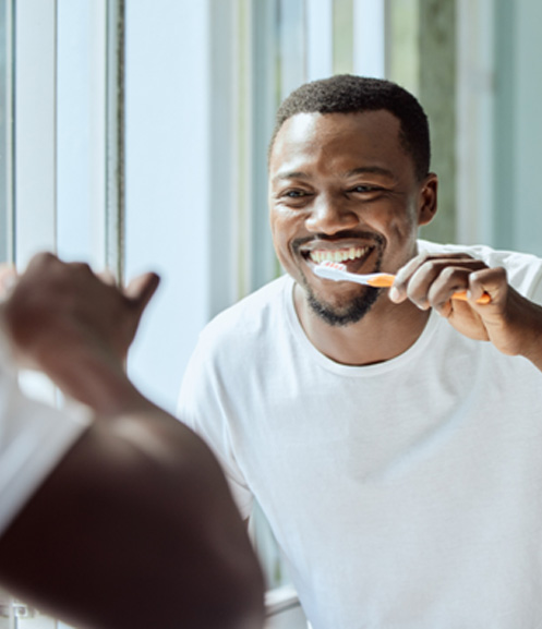 Close-up of man looking in mirror brushing his teeth